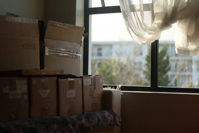 Couple carrying moving boxes into a clean, empty home